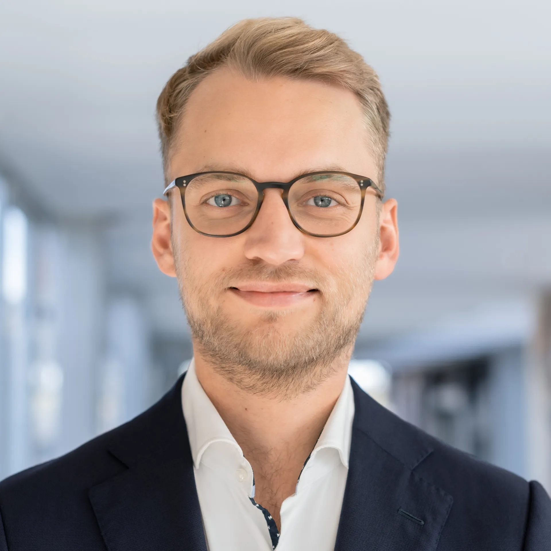 a man wearing glasses and a suit a man wearing glasses and a suit
